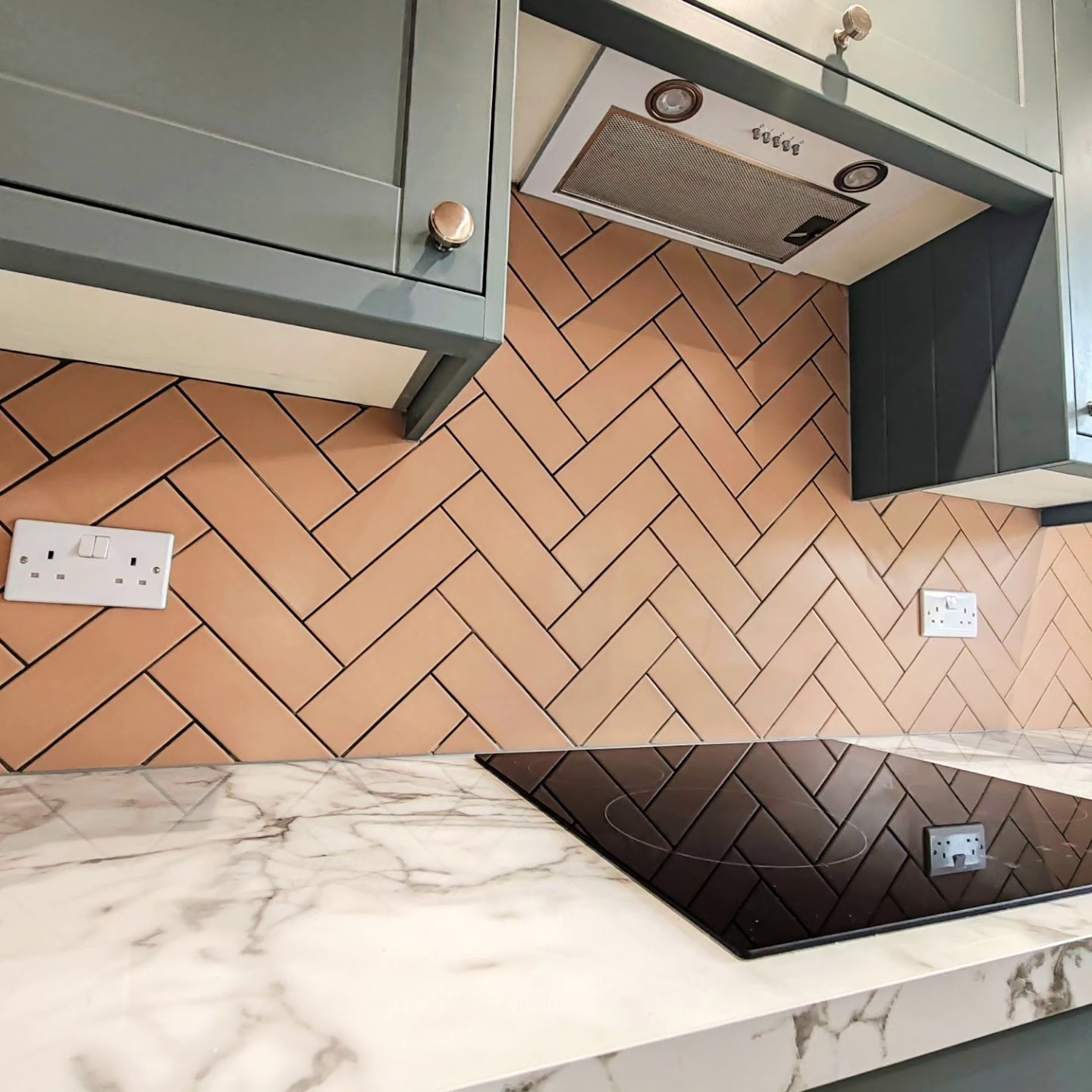 Kitchen with a terracotta herringbone tiled splashback