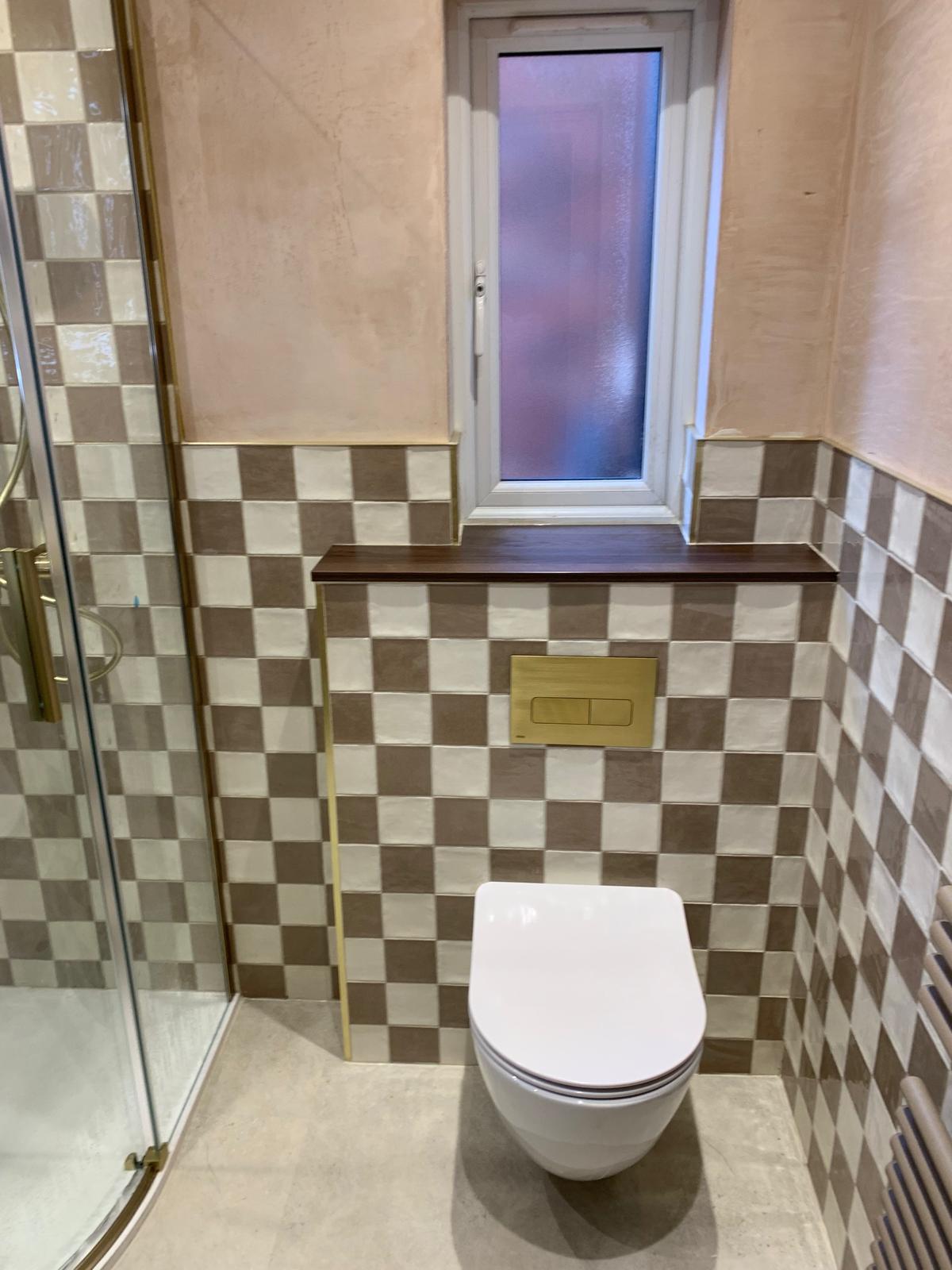 Cloakroom with checkerboard wall tiles and a wall-hung toilet