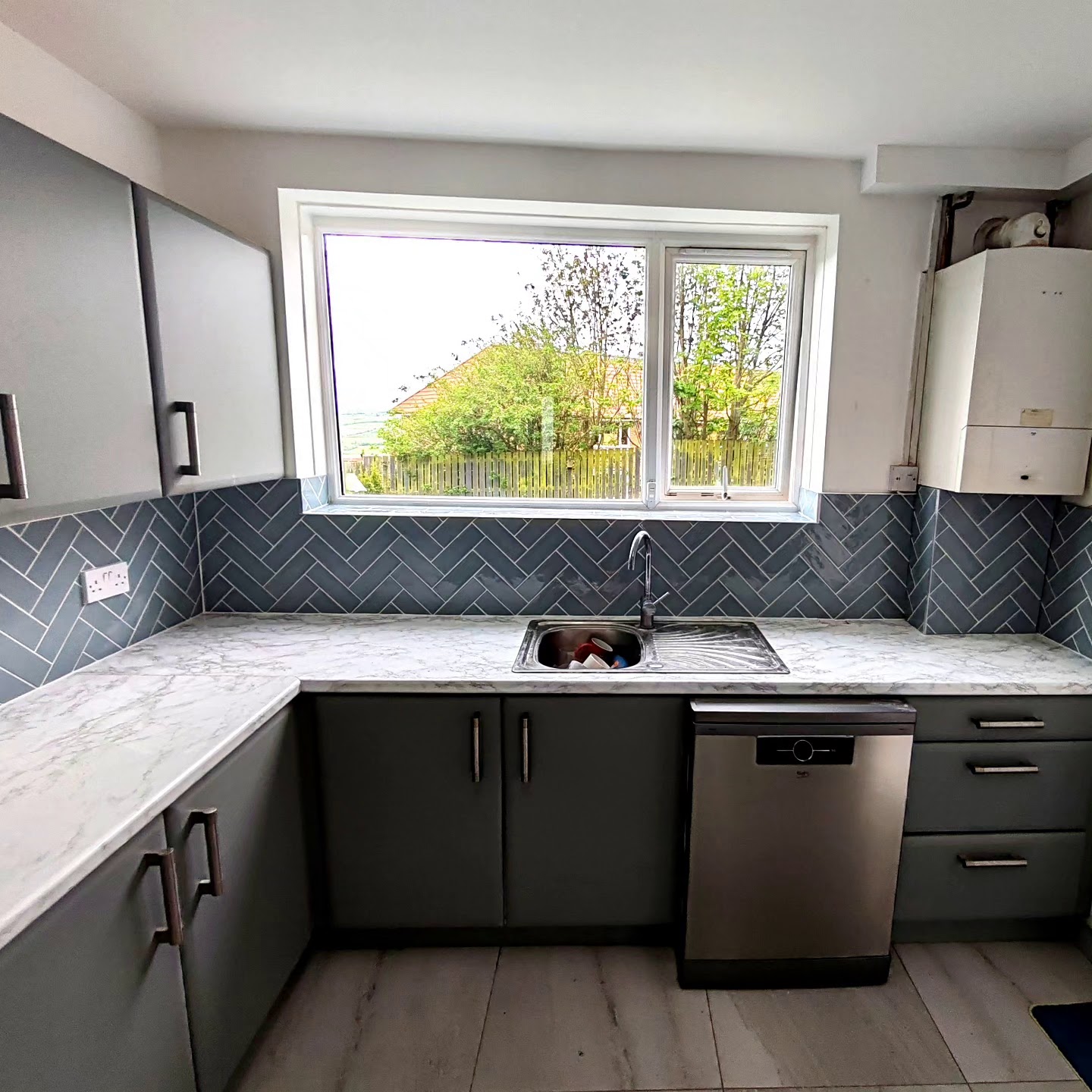 Kitchen with a grey herringbone splashback