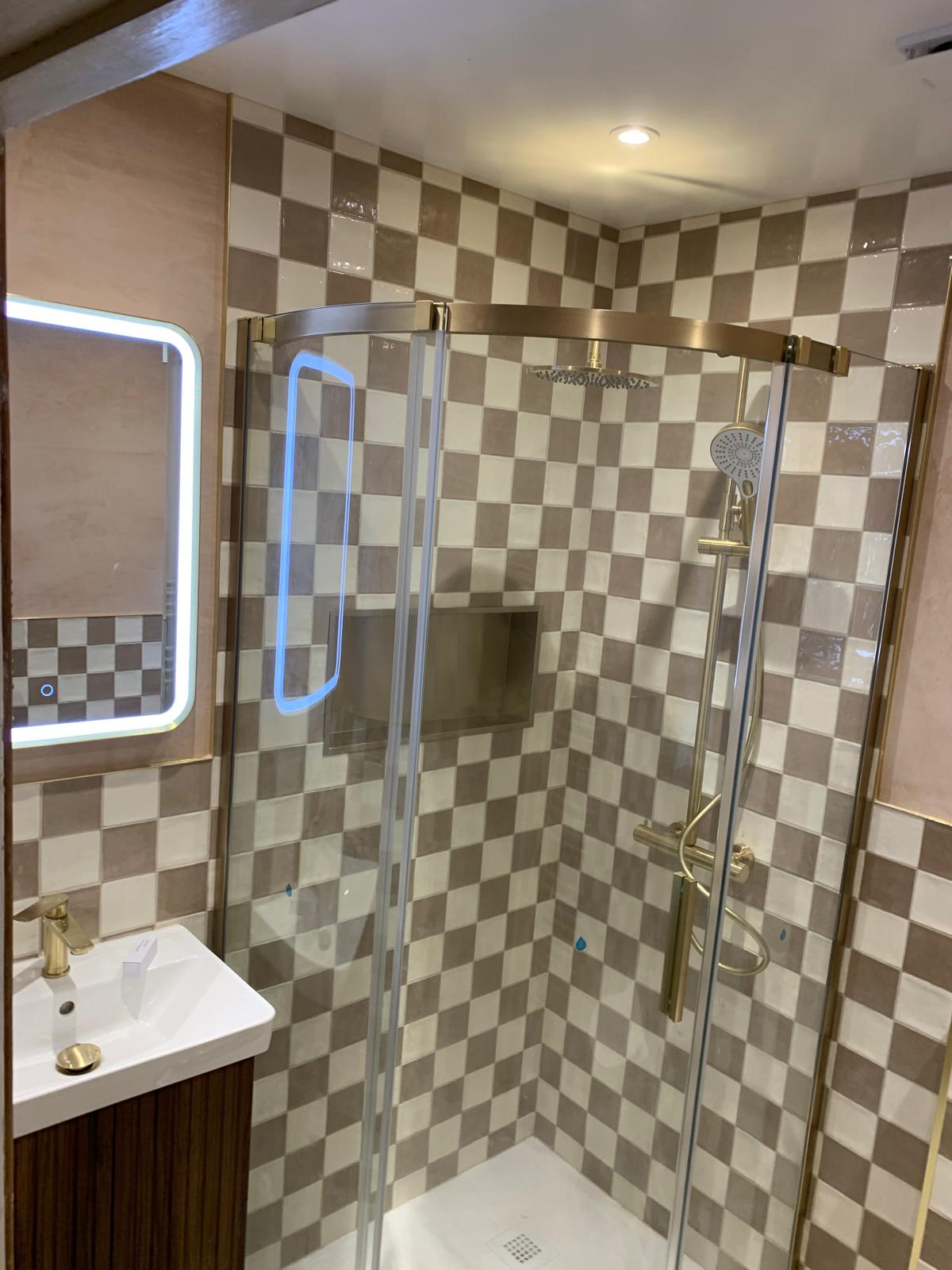 Shower tiled in a checkerboard pattern with brass fittings